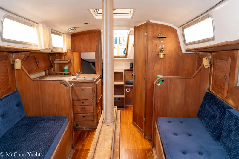 Slide: The Image of 1984 Sabre 32 Aft-Cabin interior with wooden finish and blue cushioned seating. - 51