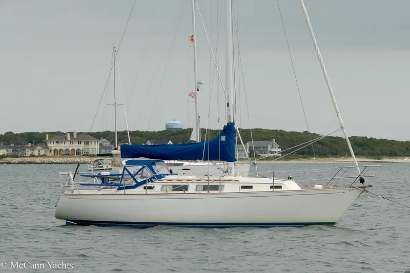 Slide: The Image of 1984 Sabre 32 Aft-Cabin sailboat anchored near coastal homes. - 7