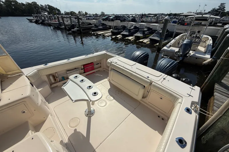 Slide: The Image of 2007 Grady-White Express 330 boat docked, featuring spacious deck and twin outboard engines. - 10