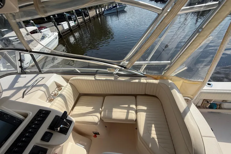 Slide: The Image of 2007 Grady-White Express 330 boat interior with seating and control panel, docked by the water. - 15