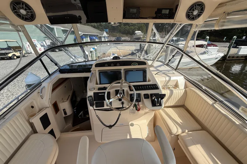 Slide: The Image of 2007 Grady-White Express 330 boat cockpit with steering wheel and navigation equipment. - 16