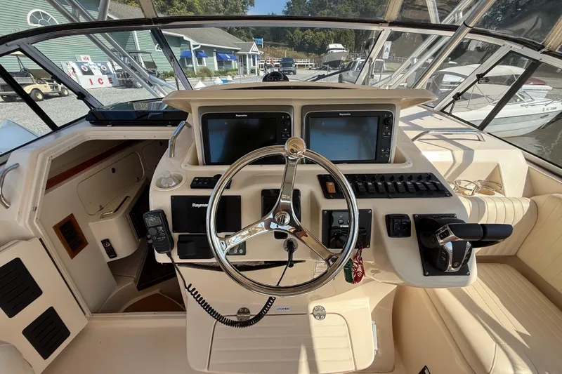 Slide: The Image of 2007 Grady-White Express 330 helm with dual Raymarine displays and steering wheel. - 19