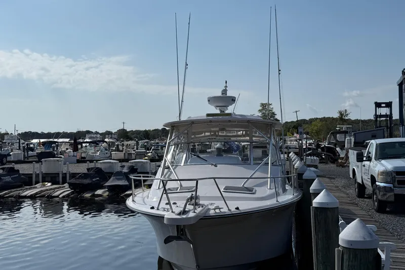 Slide: The Image of 2007 Grady-White Express 330 docked at marina, surrounded by boats and vehicles. - 2
