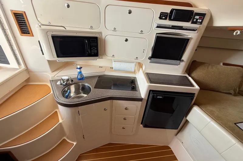 Slide: The Image of 2007 Grady-White Express 330 boat interior with kitchenette, microwave, sink, and seating area. - 22