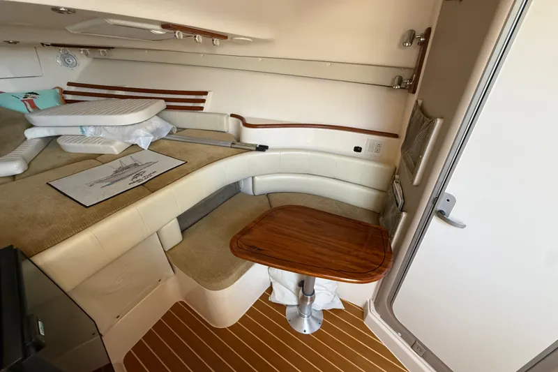 Slide: The Image of 2007 Grady-White Express 330 cabin interior with seating and wooden table. - 24