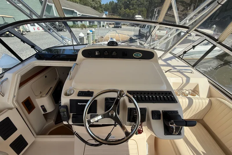 Slide: The Image of 2007 Grady-White Express 330 boat cockpit with steering wheel and control panel. - 27