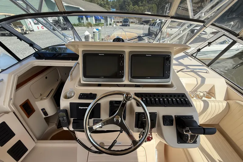 Slide: The Image of 2007 Grady-White Express 330 helm with dual Raymarine displays and steering wheel. - 28