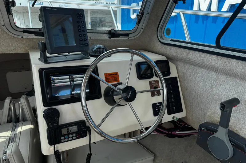 Slide: The Image of 2007 Parker 2320 SL Sport Cabin boat dashboard with steering wheel and navigation equipment. - 20