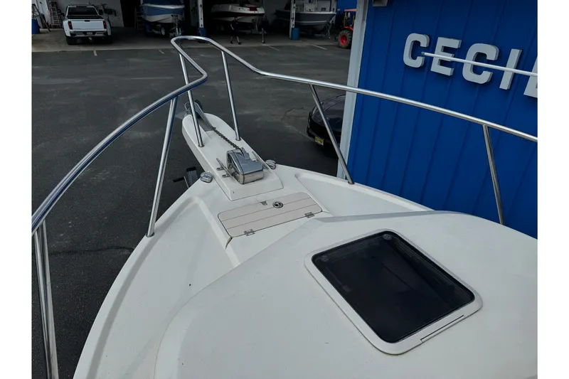 Slide: The Image of 2007 Parker 2320 SL Sport Cabin boat bow with anchor, docked near blue building. - 24