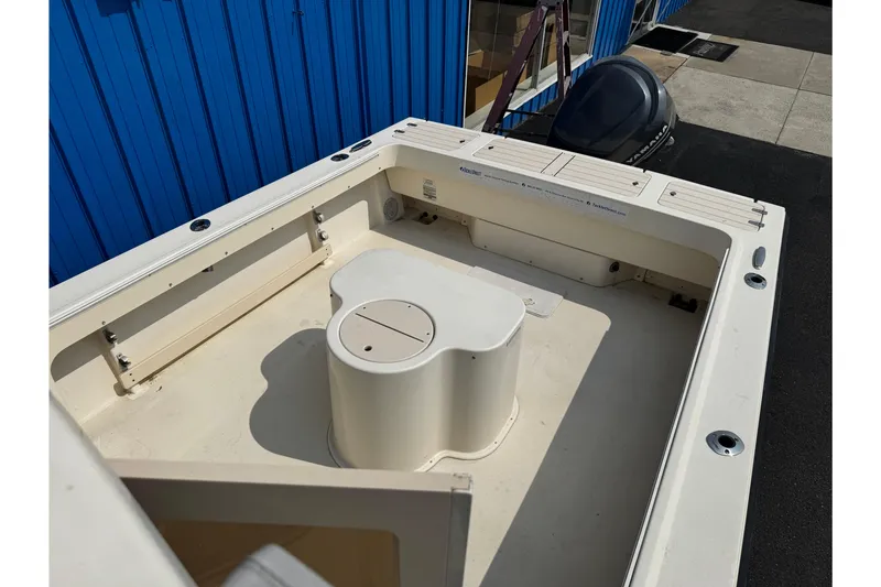 Slide: The Image of 2007 Parker 2320 SL Sport Cabin boat deck with storage compartments and blue building background. - 28