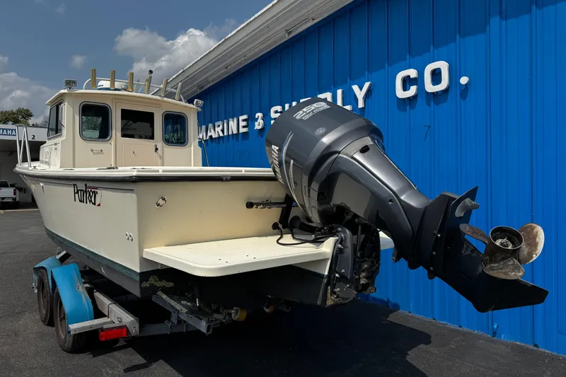 Slide: The Image of 2007 Parker 2320 SL Sport Cabin boat on trailer, parked outside marine supply store. - 4