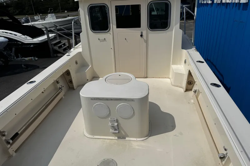 Slide: The Image of 2007 Parker 2320 SL Sport Cabin boat deck with storage compartment and cabin entrance. - 5