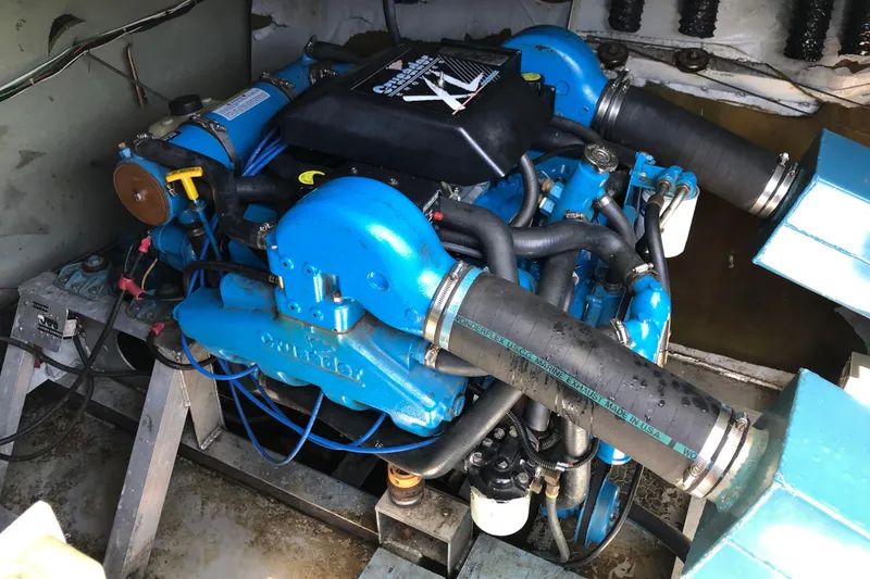 Slide: The Image of Engine compartment of a 1977 Pluckebaum Baymaster 52, featuring a blue marine engine. - 11