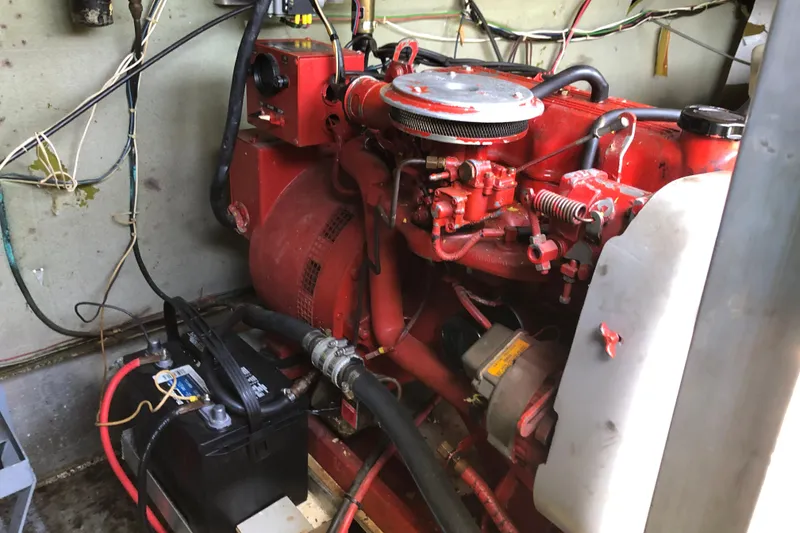 Slide: The Image of Engine room of a 1977 Pluckebaum Baymaster 52 with red machinery and wiring. - 12