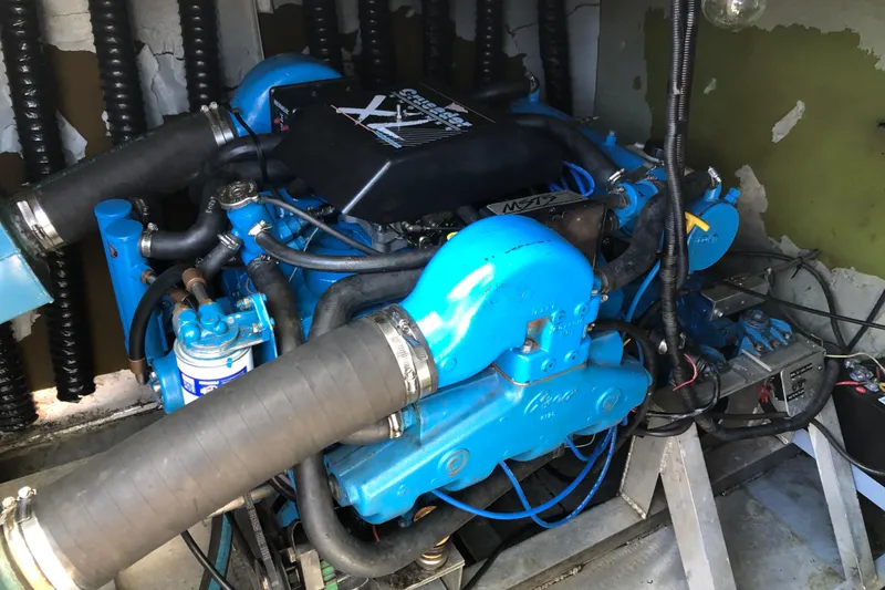 Slide: The Image of Engine room of a 1977 Pluckebaum Baymaster 52 with blue marine engine components. - 13