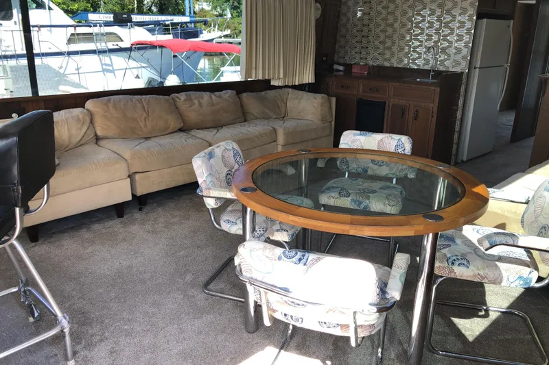 Slide: The Image of Interior of 1977 Pluckebaum Baymaster 52 with beige sofa, glass table, and patterned chairs. - 15