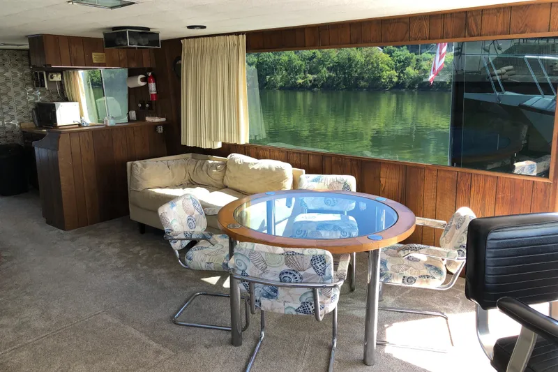 Slide: The Image of Interior of 1977 Pluckebaum Baymaster 52 with seating, table, and large window view. - 16