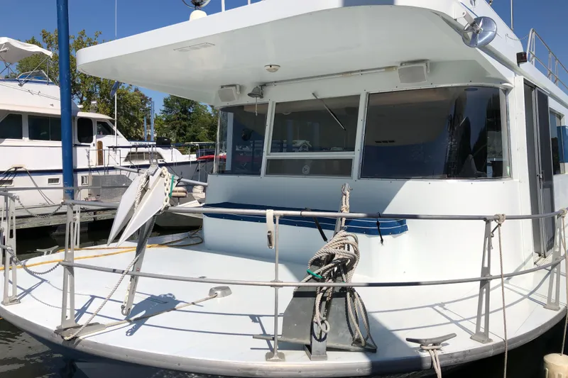 Slide: The Image of 1977 Pluckebaum Baymaster 52 yacht docked, featuring spacious deck and modern design. - 2