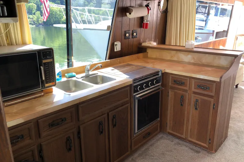 Slide: The Image of 1977 Pluckebaum Baymaster 52 kitchen with wood cabinets, stove, and microwave. - 20