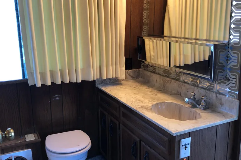 Slide: The Image of Vintage 1977 Pluckebaum Baymaster 52 bathroom with wood paneling and marble countertop. - 21