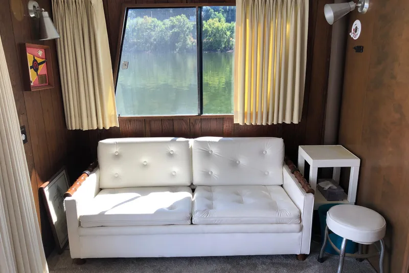Slide: The Image of Cozy interior of 1977 Pluckebaum Baymaster 52 with white sofa and lake view. - 26