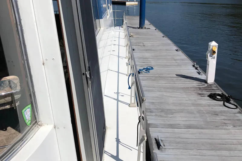 Slide: The Image of 1977 Pluckebaum Baymaster 52 docked, showing deck and marina view. - 3