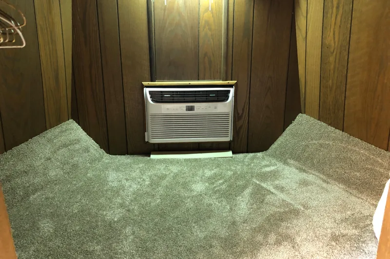 Slide: The Image of Carpeted room with wood paneling and wall-mounted air conditioner on a 1977 Pluckebaum Baymaster 52. - 33