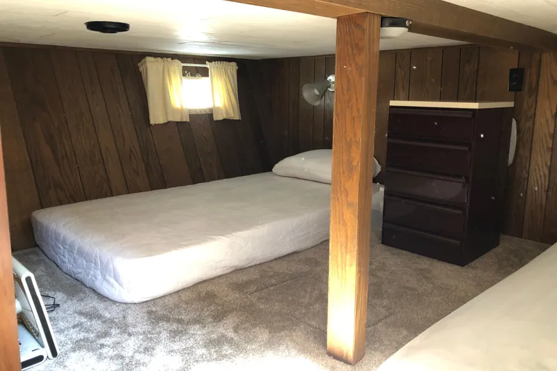 Slide: The Image of Cozy cabin interior of 1977 Pluckebaum Baymaster 52 with twin beds and wooden paneling. - 34