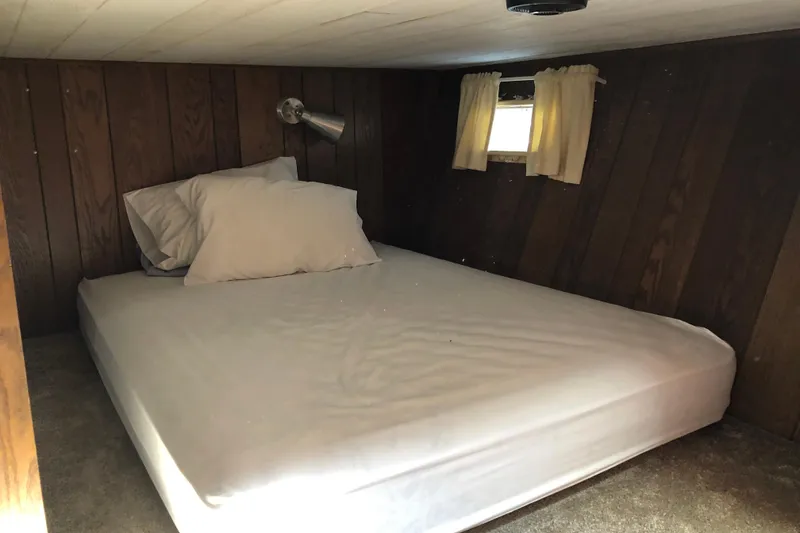 Slide: The Image of Cozy cabin bedroom in 1977 Pluckebaum Baymaster 52 with wood paneling and small window. - 35