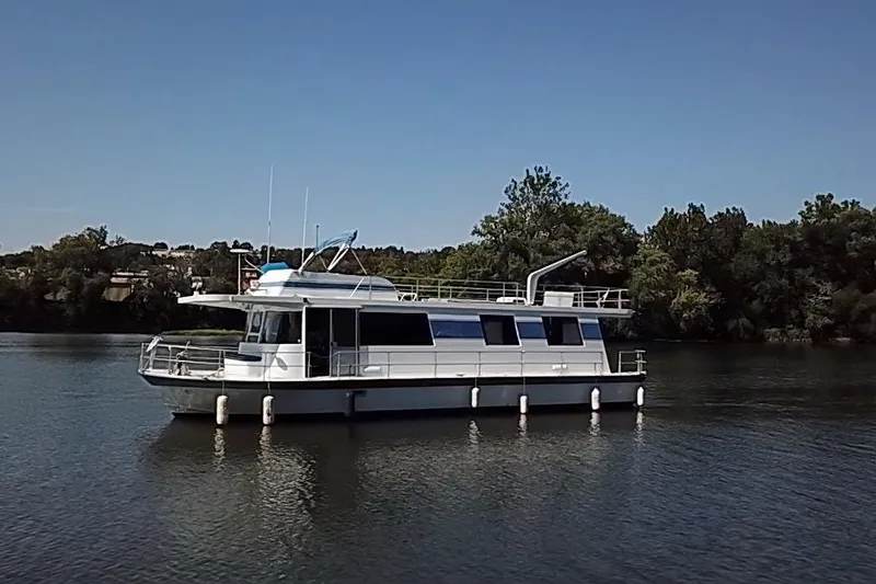 Slide: The Image of 1977 Pluckebaum Baymaster 52 X 17 Sport Cruiser on calm water, surrounded by trees. - 39