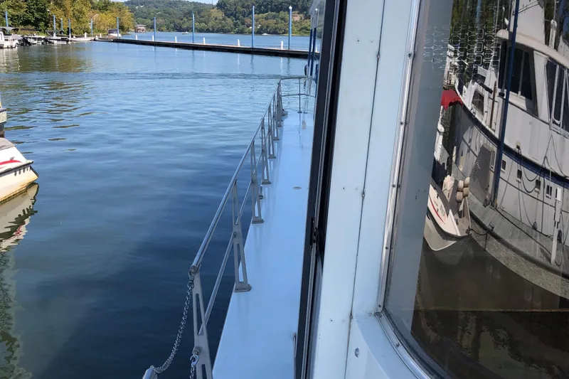 Slide: The Image of 1977 Pluckebaum Baymaster 52 yacht docked on calm water, reflecting nearby boats. - 4