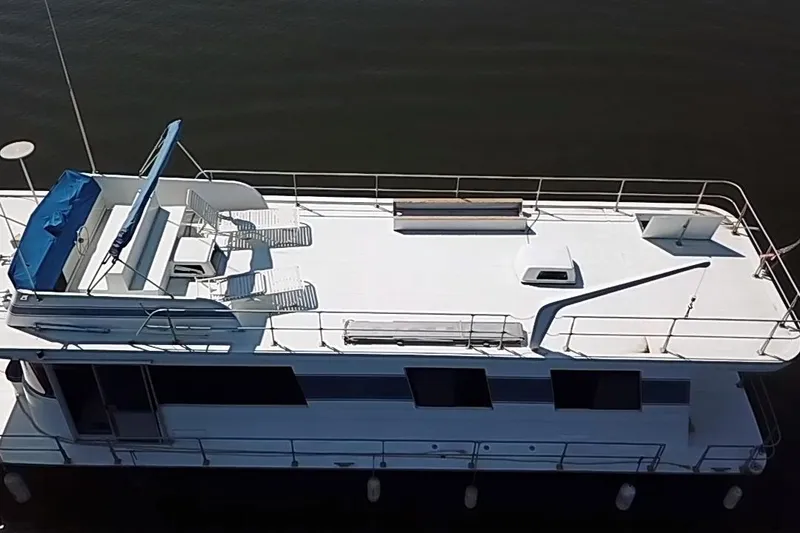Slide: The Image of 1977 Pluckebaum Baymaster 52 X 17 Walkaround Sport Cruiser, aerial view, docked on calm water. - 49