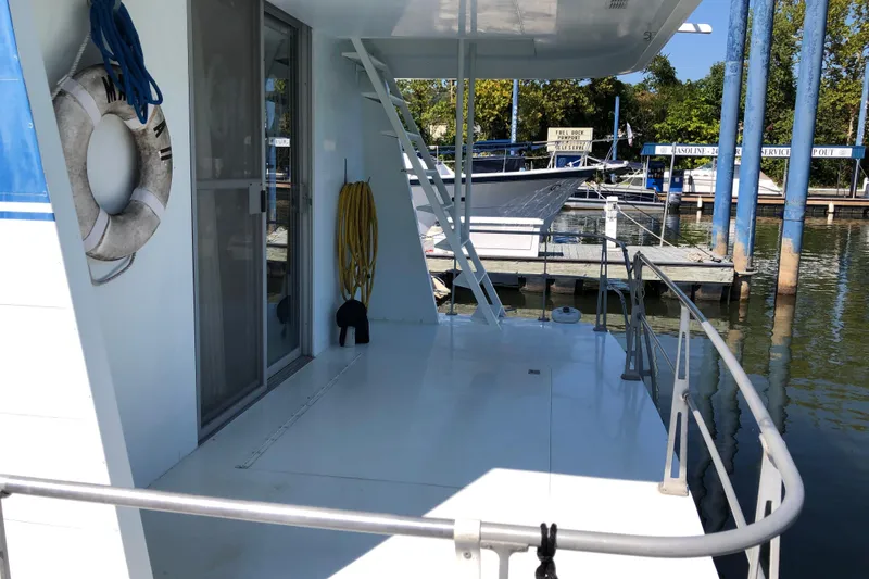 Slide: The Image of 1977 Pluckebaum Baymaster 52 docked, featuring deck with life preserver and hose. - 5