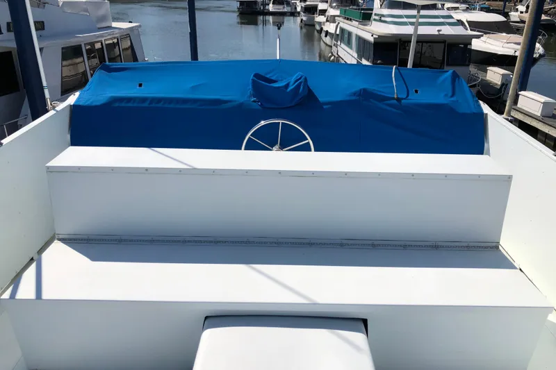 Slide: The Image of 1977 Pluckebaum Baymaster 52 boat deck with blue cover and steering wheel. - 7