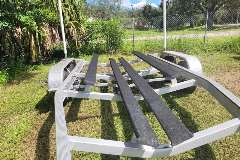 Slide: The Image of Boat trailer for 2017 NauticStar 244 XTS on grass, surrounded by greenery. - 27