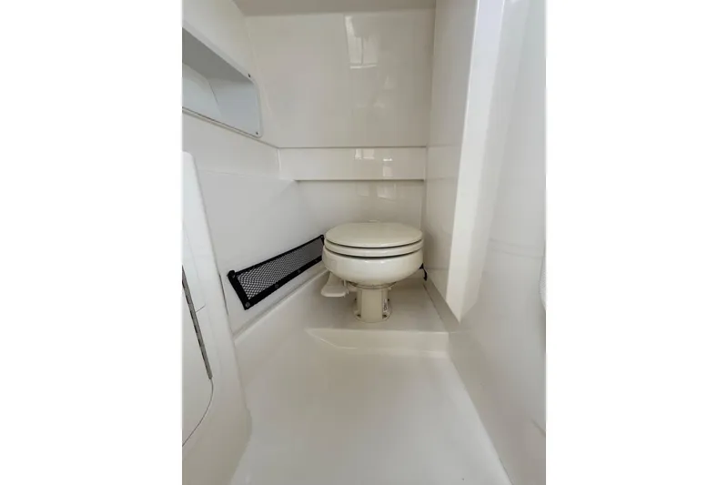 Slide: The Image of 2016 Sea Ray 270 Sundeck boat bathroom interior with white marine toilet. - 13