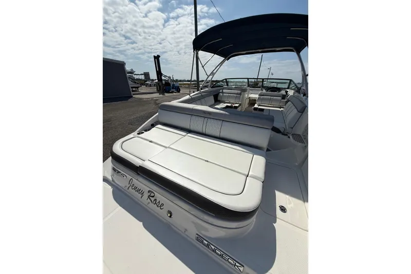 Slide: The Image of 2016 Sea Ray 270 Sundeck boat with spacious seating and canopy under a cloudy sky. - 19