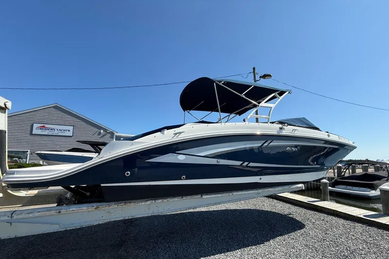 Slide: The Image of 2016 Sea Ray 270 Sundeck boat on display at a marina under clear blue sky. - 2
