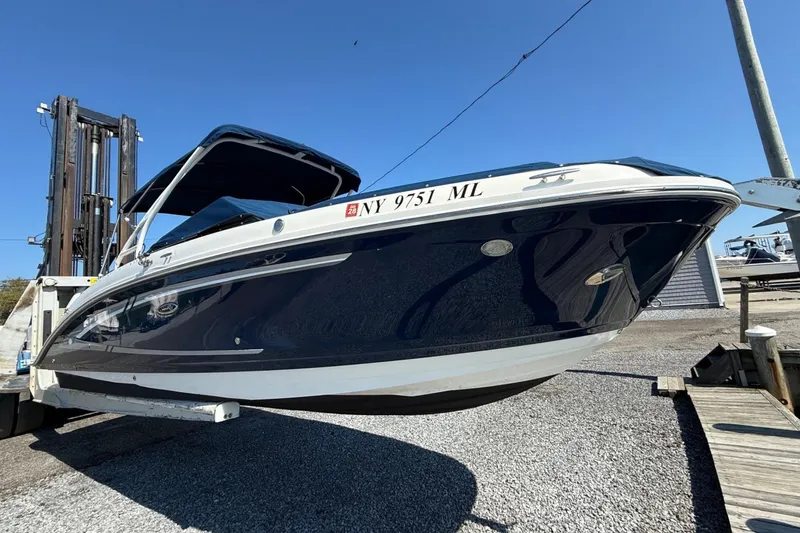 Slide: The Image of 2016 Sea Ray 270 Sundeck boat on a lift, showcasing sleek design and navy hull. - 3
