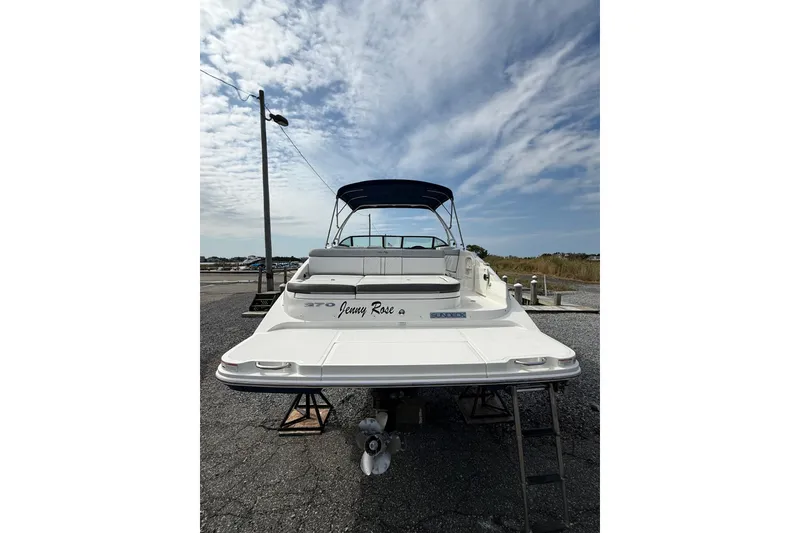 Slide: The Image of 2016 Sea Ray 270 Sundeck boat with canopy, parked on a gravel lot under a cloudy sky. - 6
