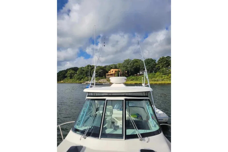 Slide: The Image of 2007 Pursuit OS 335 Offshore boat on water, with scenic shoreline and cloudy sky. - 11