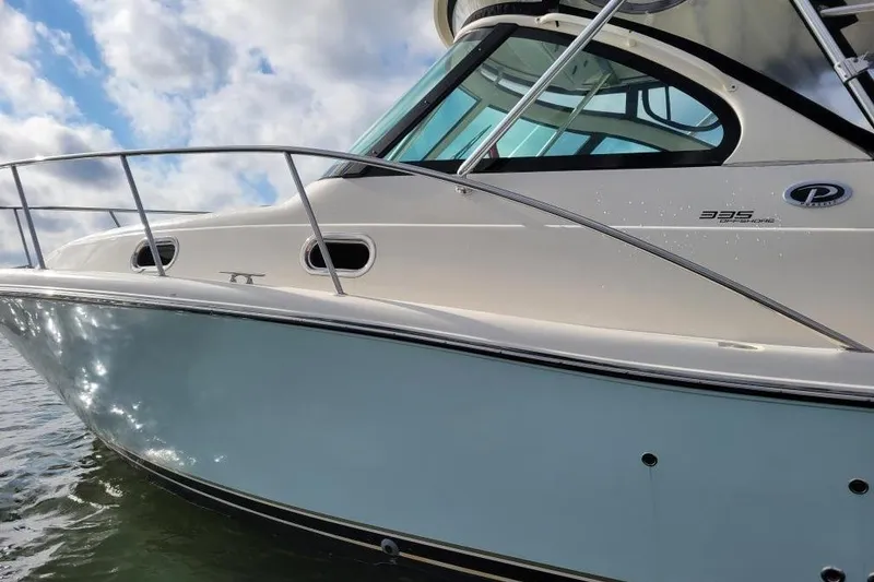 Slide: The Image of 2007 Pursuit OS 335 Offshore boat on water, showcasing sleek design and windows. - 5