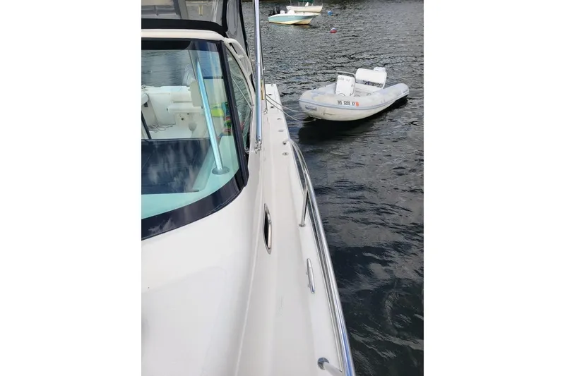 Slide: The Image of 2007 Pursuit OS 335 Offshore boat on water with inflatable dinghy nearby. - 9