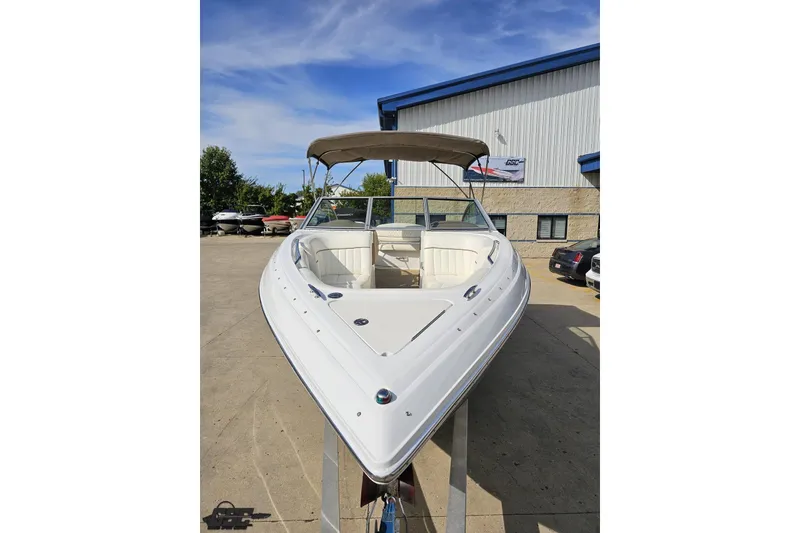 Slide: The Image of 2007 Cobalt 252 boat with canopy, parked outdoors near a building. - 14
