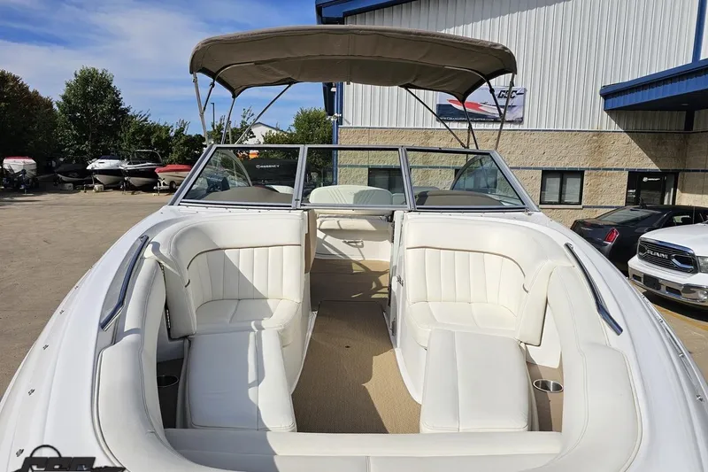 Slide: The Image of 2007 Cobalt 252 boat with white seating and canopy, parked outdoors. - 16