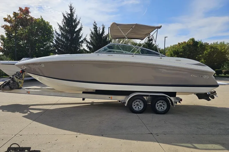 Slide: The Image of 2007 Cobalt 252 boat on trailer, parked outdoors with trees in background. - 19