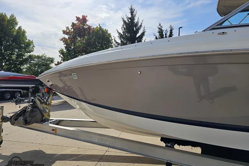 Slide: The Image of 2007 Cobalt 252 boat on trailer, parked outdoors under a clear sky. - 21
