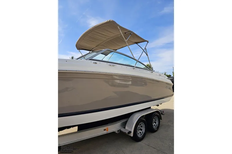 Slide: The Image of 2007 Cobalt 252 boat on trailer with canopy against blue sky. - 23