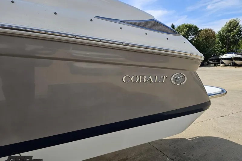 Slide: The Image of 2007 Cobalt 252 boat side view with logo, parked outdoors. - 24