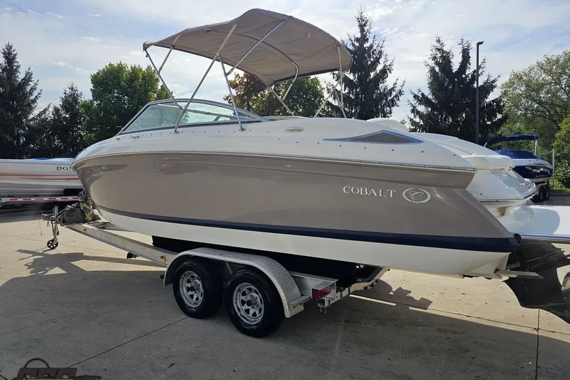 Slide: The Image of 2007 Cobalt 252 boat on trailer with canopy, parked outdoors. - 26